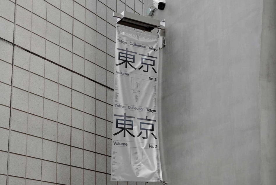 Hanging banner mockup displaying Tokyo Collection text on a tiled wall perfect for showcasing urban design projects or typography.