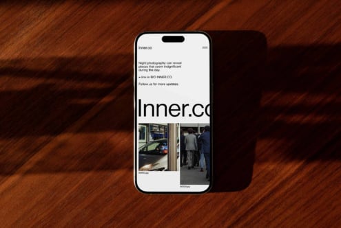 Smartphone displaying a mockup website on a wooden surface. Ideal for showcasing web design, templates, user interface, mobile layout.