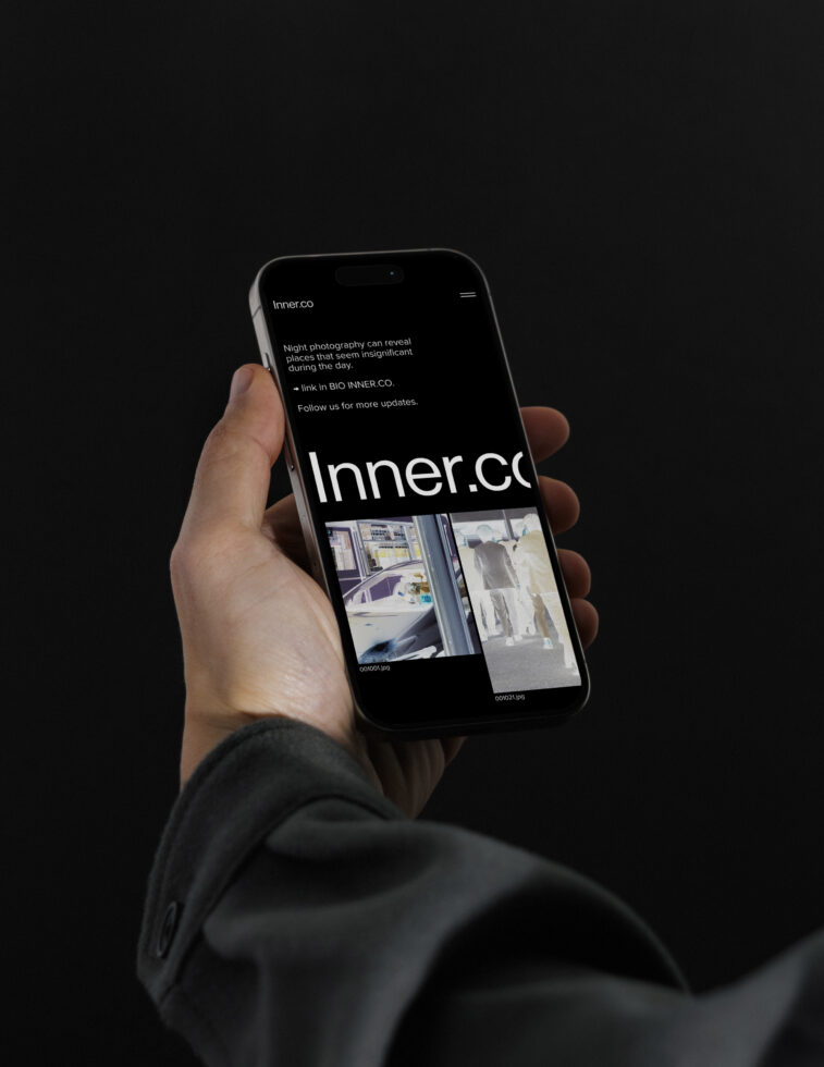 Mockup of a hand holding a smartphone displaying a night photography webpage. Ideal for designers seeking realistic phone display mockups in dark settings.