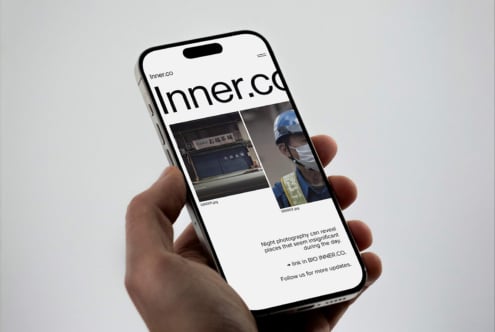 Hand holding smartphone displaying website with images for digital design. Ideal for mockups, showcasing creative online portfolios and UI/UX design drafts.