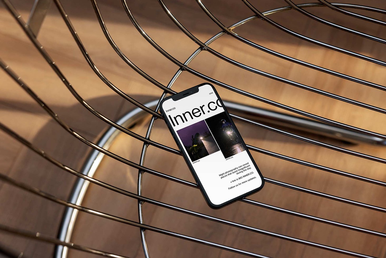 Smartphone on modern wire chair displaying a website with photography content suitable for digital assets mockups designers tech UI smartphone SEO