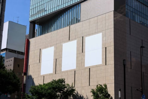Urban building facade with three blank vertical billboards for advertising design mockup city architecture background ideal for graphic designers.