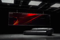 Modern interior mockup featuring a large digital screen with abstract red design above a sleek black leather sofa. Ideal for design presentations.