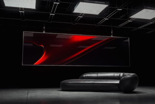 Modern interior mockup featuring a large digital screen with abstract red design above a sleek black leather sofa. Ideal for design presentations.
