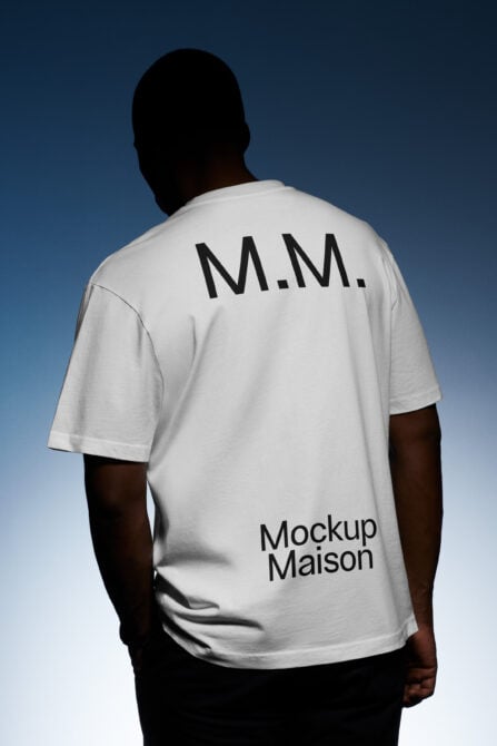 Back view of a person wearing a white t-shirt featuring bold text M.M. and Mockup Maison logo against a gradient backdrop. Ideal for apparel mockup use.