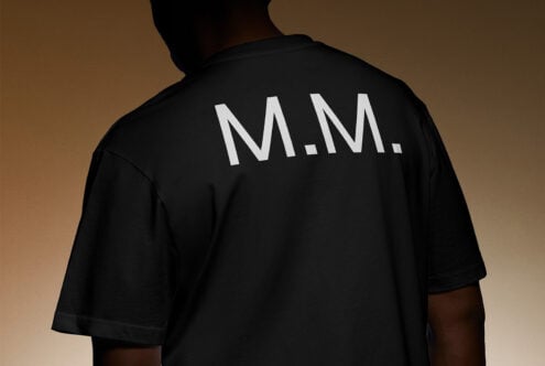Back view of person wearing black shirt with white lettering MM suitable for apparel mockup designers showcasing bold typography fashion template design