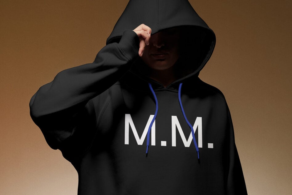 Hoodie mockup featuring a person wearing a black hoodie with M. M. text design. Perfect for apparel designers and fashion branding projects.