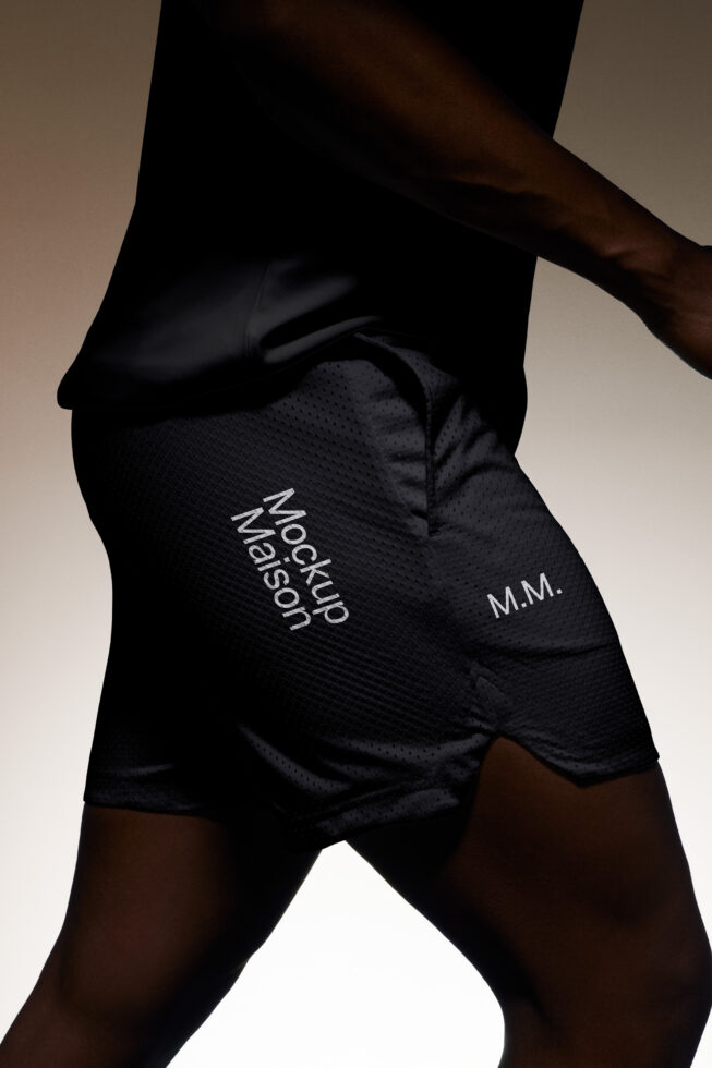 Close-up of person wearing black shorts with Mockup Maison text perfect for fashion mockups sportswear templates and graphic design projects.