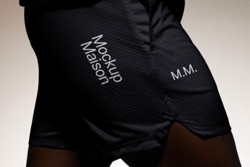 Black sports shorts mockup with textured fabric showcasing Mockup Maison branding on left leg. Ideal for designers seeking clothing template visuals.