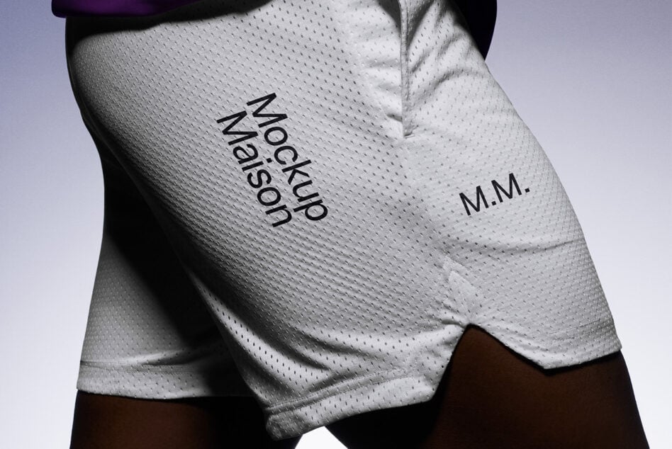 White mesh shorts with M.M. logo on thigh against purple backdrop