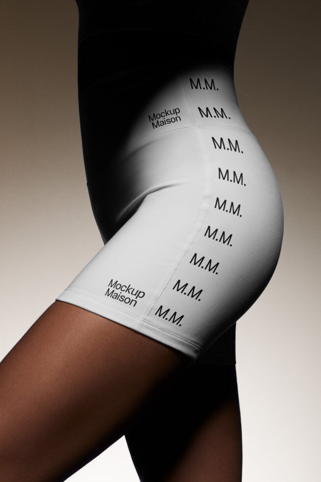 Side view of a person wearing branded white shorts with lettering M.M. and Mockup Maison. Ideal for designers seeking high-quality apparel mockups.