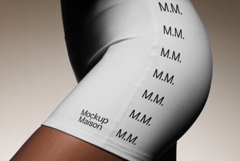 White bike shorts featuring repeating M.M. text and Mockup Maison logo on side. Ideal for apparel mockup. Perfect for designers seeking clothing graphics.