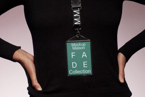 Person wearing a black sweater showcasing a lanyard with a green badge reading Mockup Maison FADE Collection perfect for designers mockups SEO.