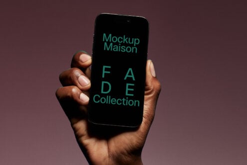 Hand holding smartphone displaying Mockup Maison FADE Collection text digital mockup template for design assets on gradient background perfect for designers.