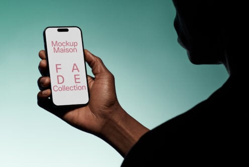 Dark hand holds smartphone displaying digital mockup text FADE Collection on screen against green backdrop ideal for designers graphics templates SEO