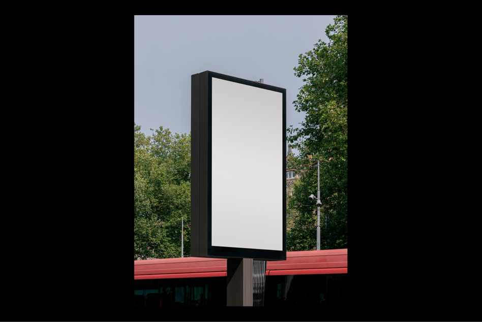 Blank vertical billboard mockup in urban setting surrounded by trees ideal for showcasing advertising designs and graphic templates for designers.