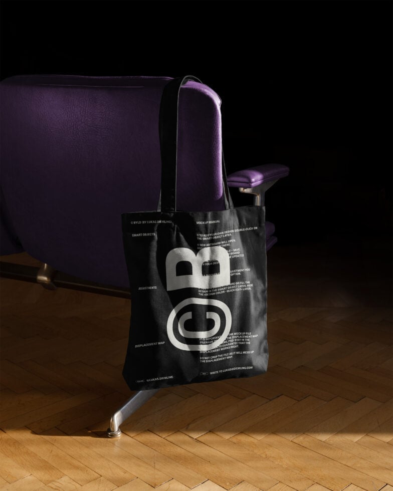 Tote bag mockup showcasing bold typography draped over a purple chair; ideal for presenting custom designs in graphic and fashion design projects.