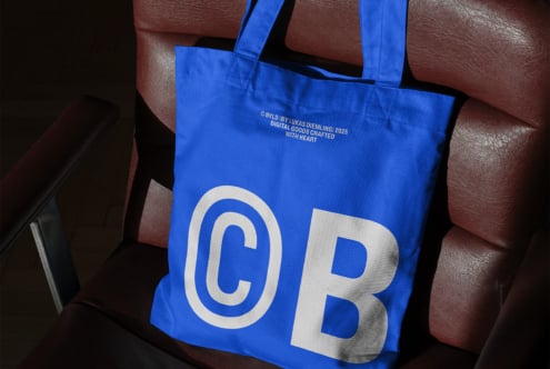 Blue tote bag mockup on a leather chair showcasing bold white typography and minimal design, perfect for branding and marketing visuals for designers.