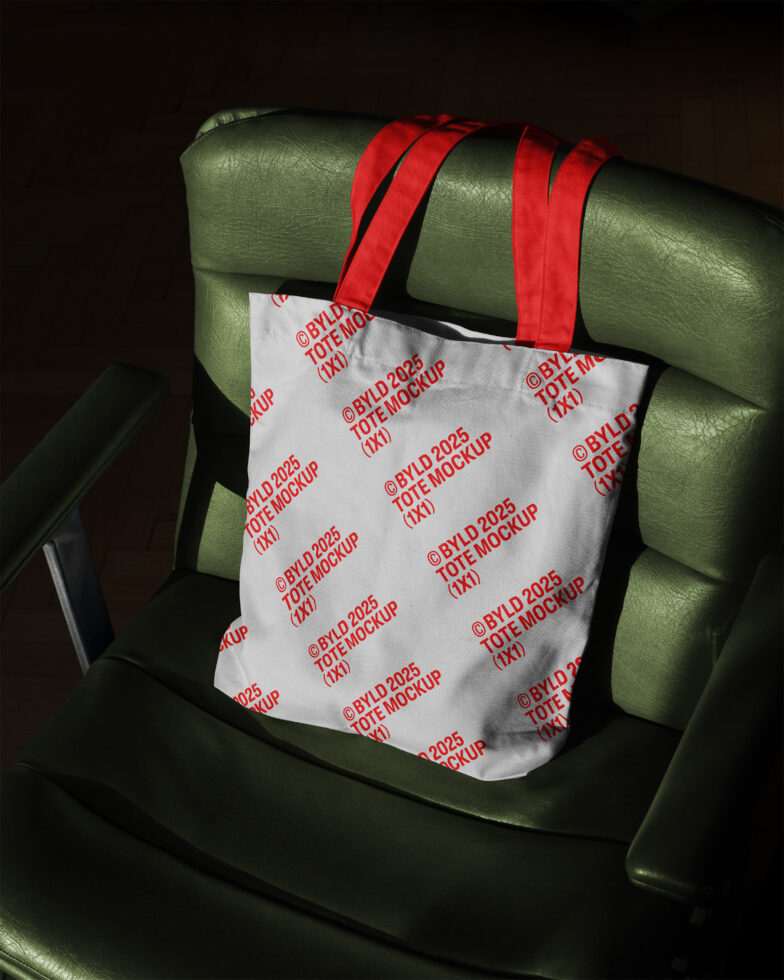 Tote bag mockup with red handles on a green chair showcasing design layout for digital assets in mockups templates category ideal for designers.