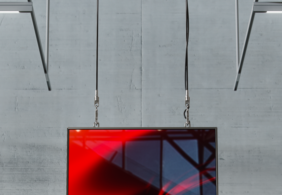 Hanging digital screen mockup with red abstract design, cables attached to a metal frame in an industrial setting. Ideal for graphics designers.