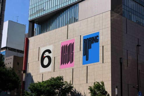 Urban building facade with three bold graphic posters. Contemporary typography design featuring numbers and words. Perfect for design mockups.