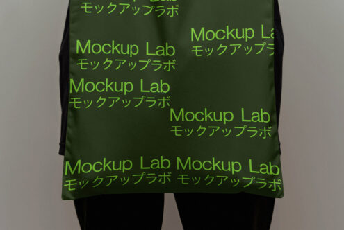 Green tote bag mockup featuring repeated text Mockup Lab with Japanese characters. Ideal for branding projects and design presentations. Mockup graphics.