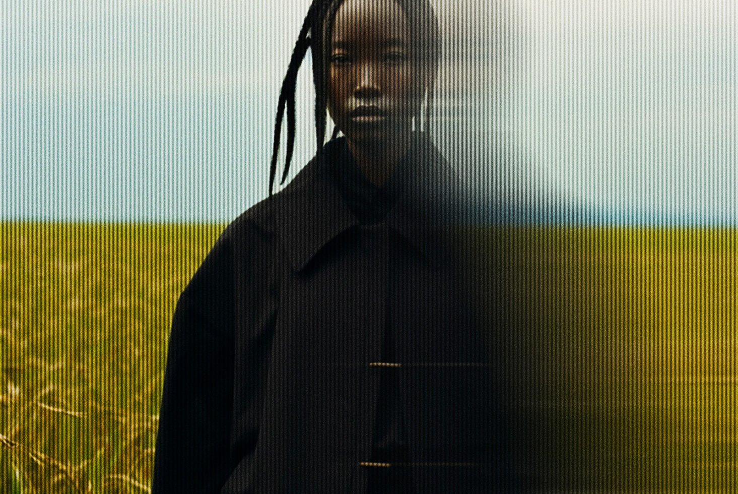 Blurred portrait of person in black coat with textured overlay and green field background creative photography mockup for designers and digital artists