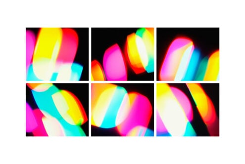 Colorful abstract light patterns with red, blue, yellow, and pink shapes on a black background. Ideal for graphic design, templates, creative projects.