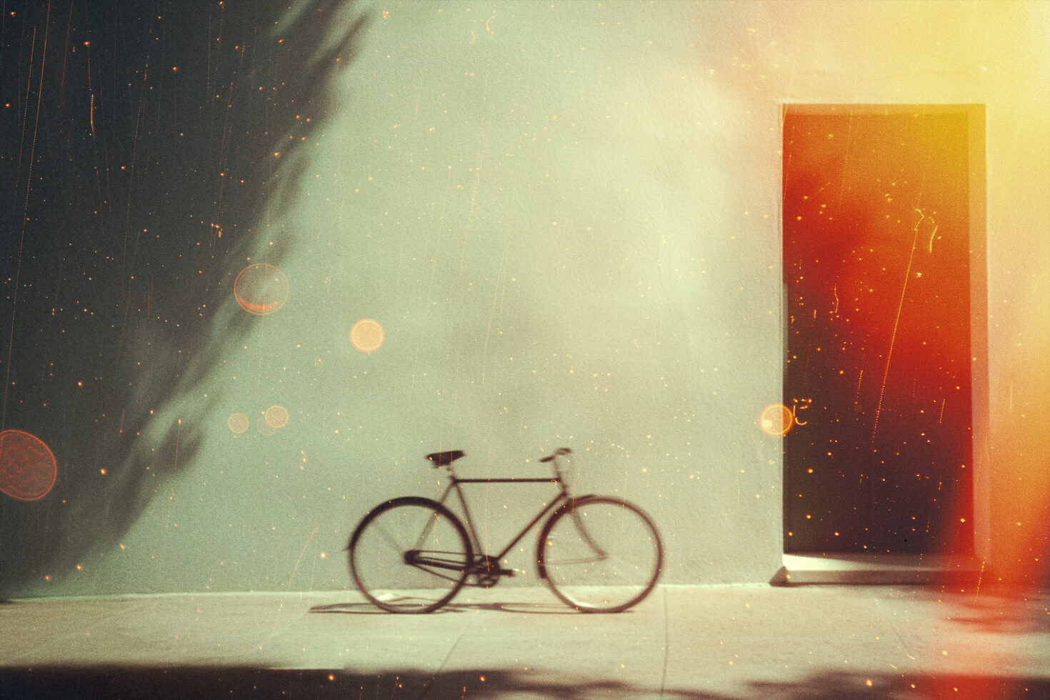 Bicycle against a vintage green wall with open door and light leaks. Ideal for graphics or templates emphasizing retro aesthetics and creative design.