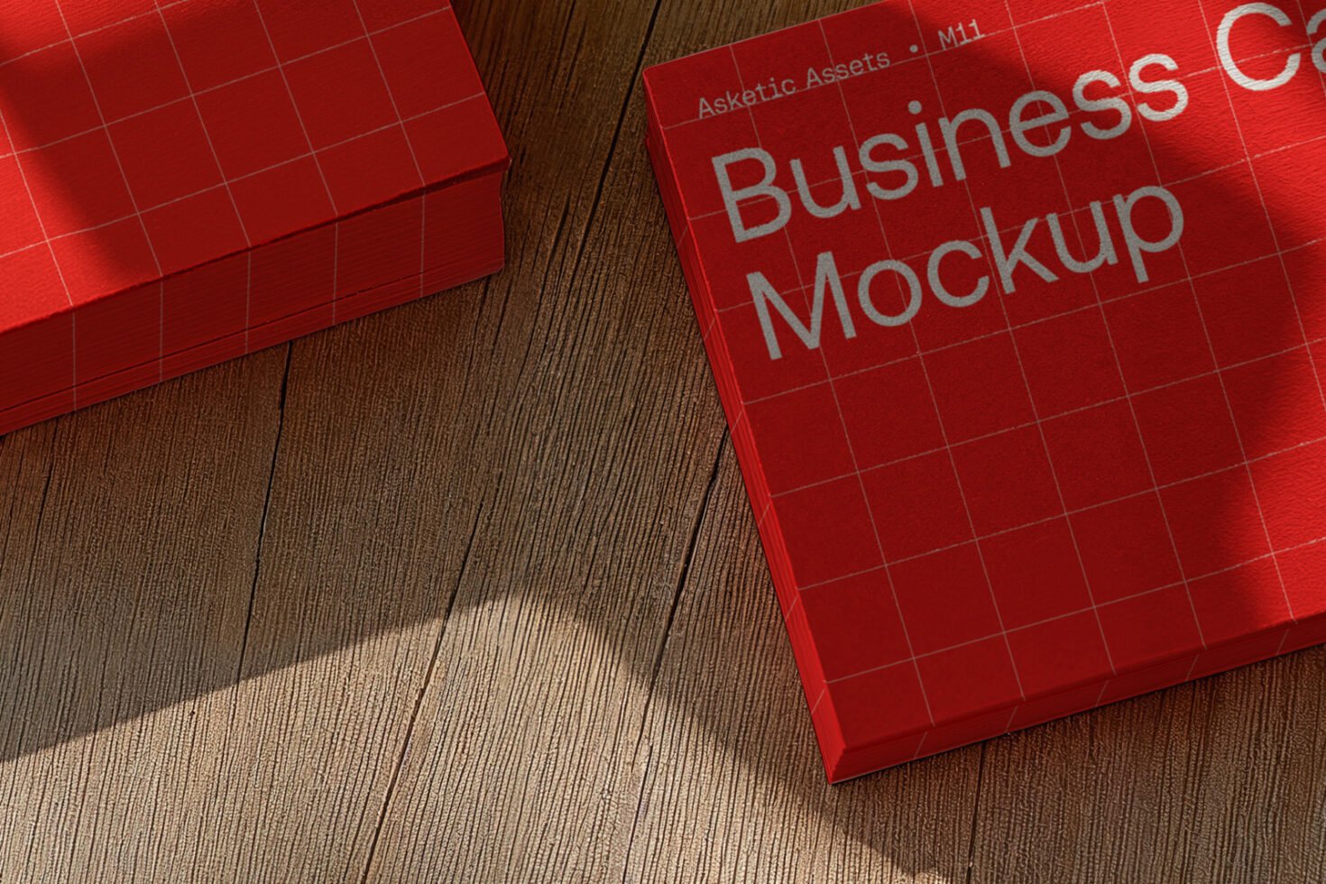Red business card mockup on wood surface showcasing grid design and text layout for branding. Ideal for designers needing realistic presentation templates.