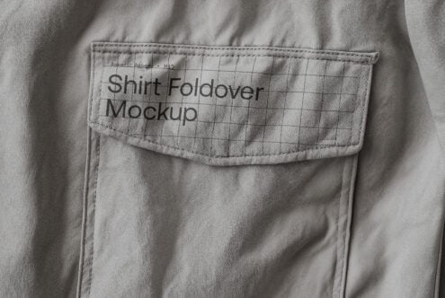 Close-up of a gray shirt foldover with label saying Shirt Foldover Mockup with grid pattern. Perfect for showcasing apparel branding and design templates.