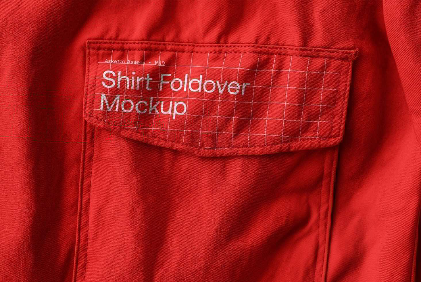 Red shirt close-up showcasing pocket design with grid lines and Shirt Foldover Mockup text suitable for apparel mockups and textile graphics designers