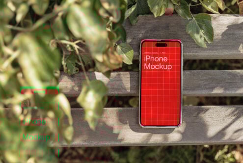 iPhone mockup on wooden bench with green leaves background bright red screen grid design digital asset for designers PSD mockups mobile templates