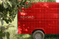 Red cargo van with plant branches in foreground, bright natural light reflecting