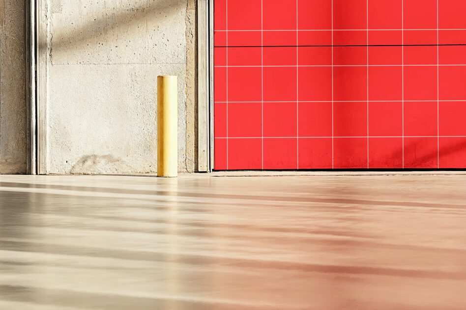 Bright red tile wall backdrop with gold bollard pole on wooden warehouse floor