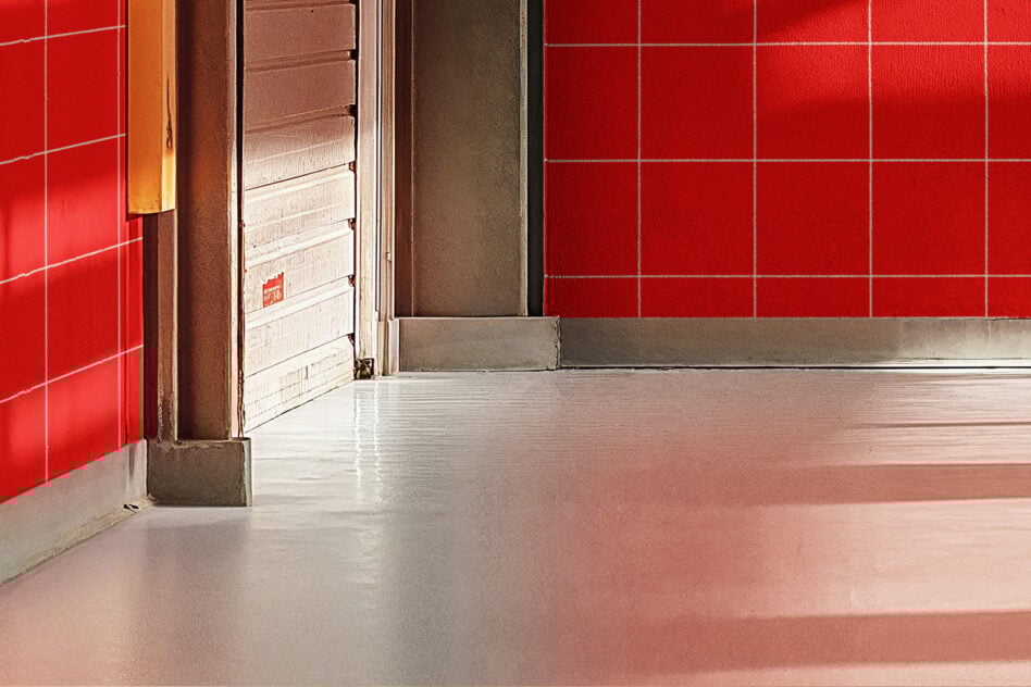 Red and beige interior wall with sleek reflective floor showcasing modern industrial design ideal for backgrounds or templates for designers.