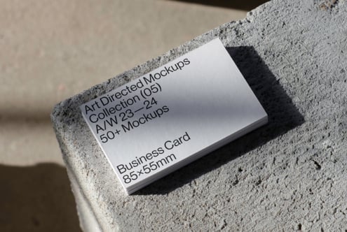 Business card mockup featuring minimalistic design on textured stone surface. Perfect for designers seeking modern branding templates and realistic graphics.