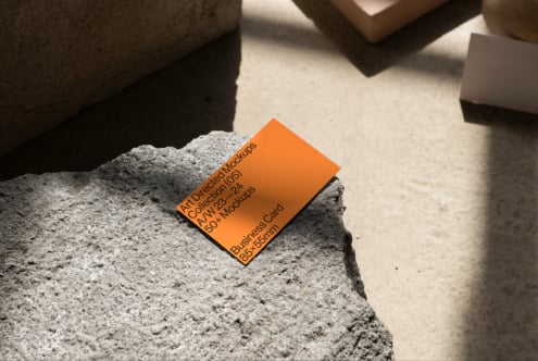 Orange business card mockup on concrete surface suitable for designers. High-quality mockups business card template PSD resource for creatives.