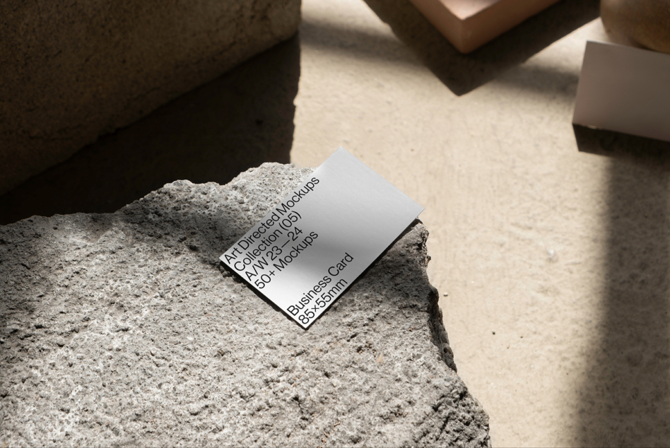 Business card mockup on textured concrete surface, showcasing modern design for creative mockups, templates, design assets targeting graphic designers.