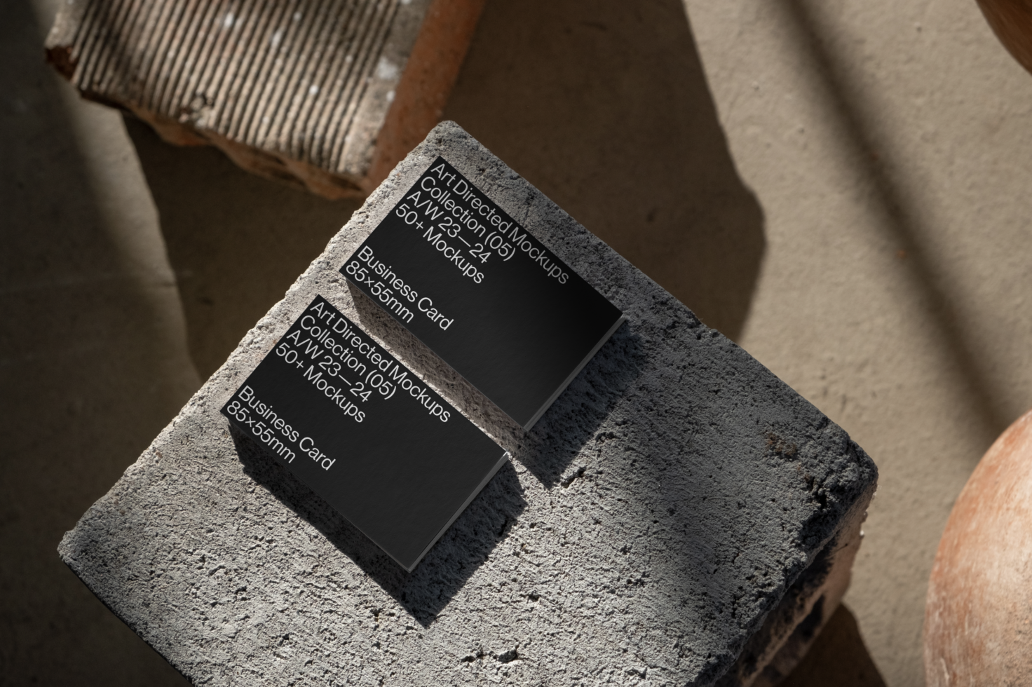 Business card mockup on textured stone surface with natural sunlight shadows. Ideal for designers seeking realistic presentation templates and mockups.