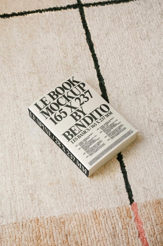 Book mockup on textured carpet showcasing cover design with bold typography. Ideal for designers seeking realistic presentations. Graphic template assets.