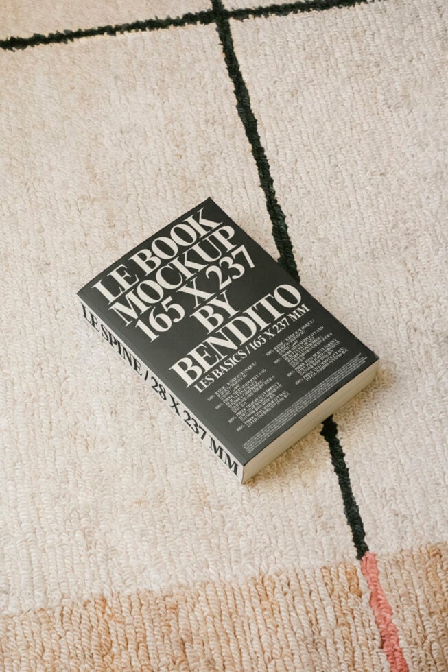 Book mockup lying on a textured rug perfect for showcasing cover designs. Ideal for designers. Keywords: book mockup design template graphic.
