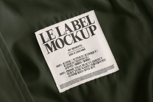 Fabric texture label mockup featuring a white label with bold typography on green fabric background perfect for apparel designers and branding presentations
