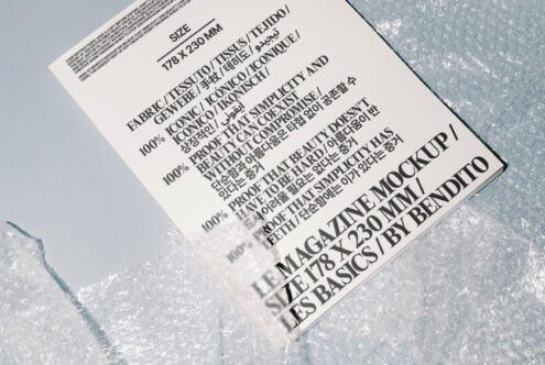 Magazine mockup with diverse typography design in multiple languages on white page surrounded by bubble wrap. Ideal for showcasing print layouts.