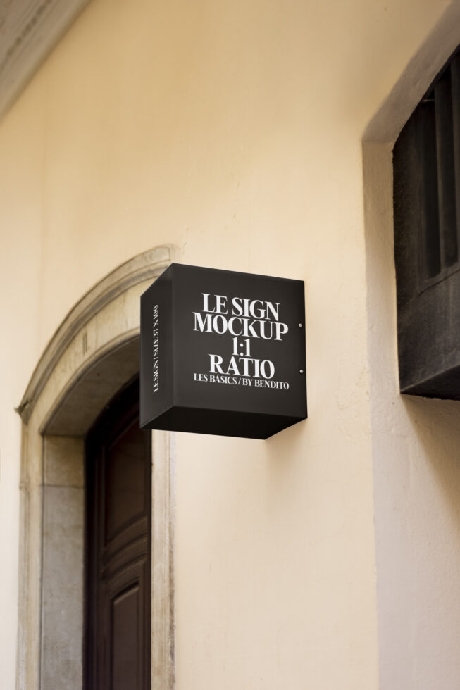 Wall-mounted sign mockup with a black square design featuring text. Perfect for showcasing logo designs. Ideal for graphic designers and branding projects.