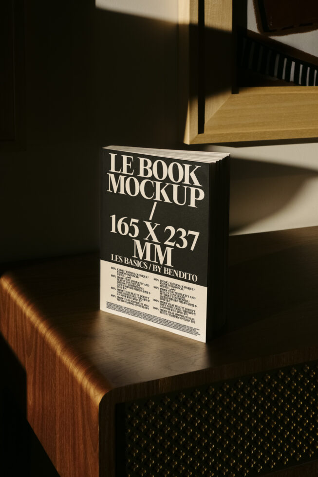Hardcover book mockup on wooden shelf with black cover showing Le Book title