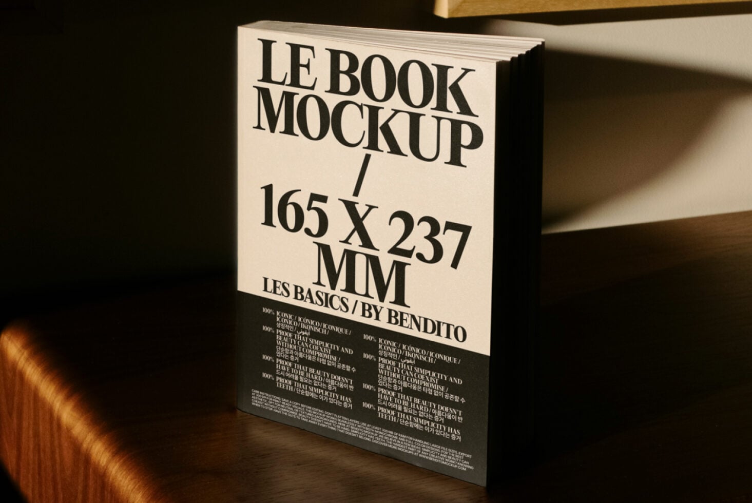 Cream hardcover book mockup tilted on shelf with black cover showing typography