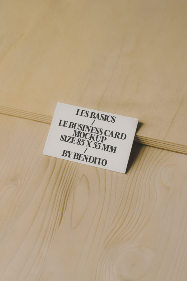 Business card mockup on a wooden surface featuring minimalist design in 85x55mm size ideal for branding presentations graphic design showcase.