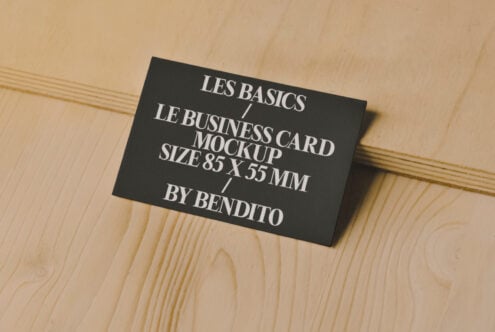 Business card mockup on wooden surface showcasing 85x55mm size. Ideal for designers seeking professional graphics and template resources.