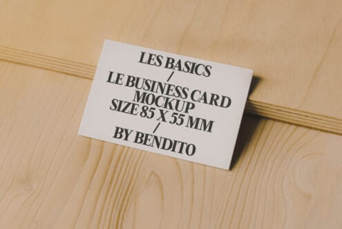 Business card mockup on wooden surface for designers. Perfect for showcasing designs. Size 85 x 55 mm. Ideal for branding presentations.